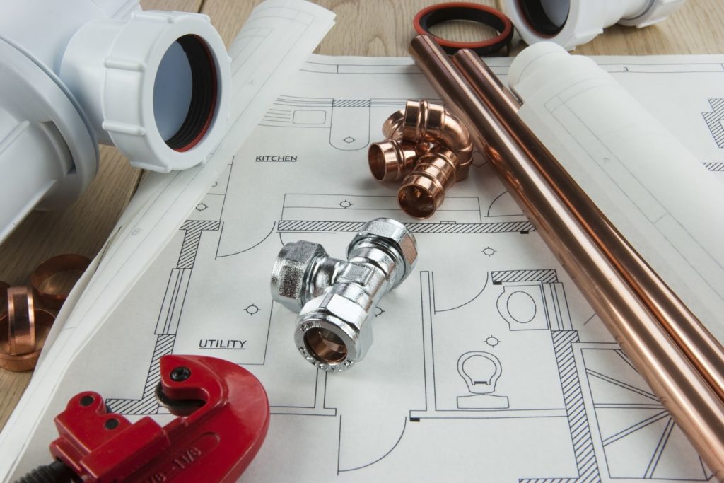 A detailed blueprint featuring various plumbing supplies, including pipes, fittings, and tools, arranged for installation planning.