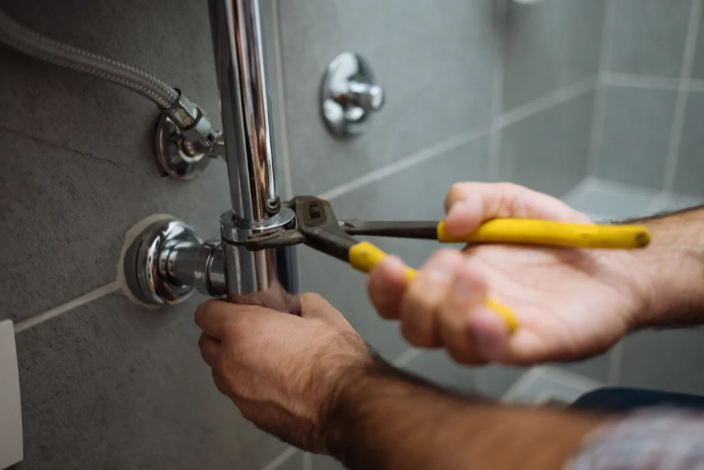 A man is repairing a shower faucet, focused on ensuring proper functionality and water flow.